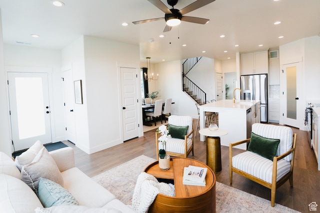 866 S 320 E Unit 168, Spanish Fork, UT 84660 - living area with light wood finished floors, recessed lighting, a ceiling fan, stairs, and a chandelier