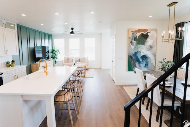 866 S 320 E Unit 168, Spanish Fork, UT 84660 - kitchen with a sink, a kitchen breakfast bar, light wood finished floors, a chandelier, and light countertops