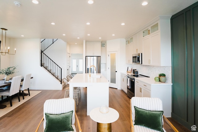 866 S 320 E Unit 168, Spanish Fork, UT 84660 - kitchen featuring stainless steel appliances, light wood-style floors, a kitchen island with sink, light countertops, and recessed lighting