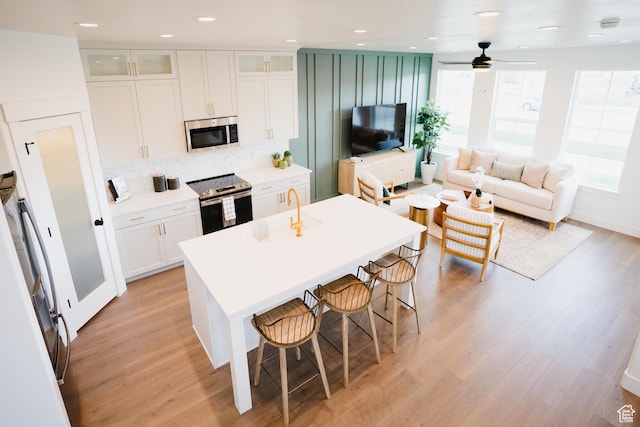 866 S 320 E Unit 168, Spanish Fork, UT 84660 - kitchen with stainless steel appliances, healthy amount of natural light, a kitchen island with sink, light wood finished floors, and recessed lighting