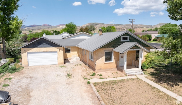 97 N 400 W, Aurora, UT 84620 - view of front of home featuring driveway, brick siding, a mountain view, a garage, and metal roof
