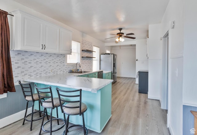 97 N 400 W, Aurora, UT 84620 - kitchen featuring appliances with stainless steel finishes, a sink, light countertops, a peninsula, and white cabinets