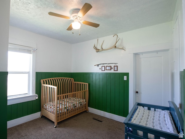 97 N 400 W, Aurora, UT 84620 - bedroom with a wainscoted wall, a textured ceiling, carpet flooring, a nursery area, and a ceiling fan
