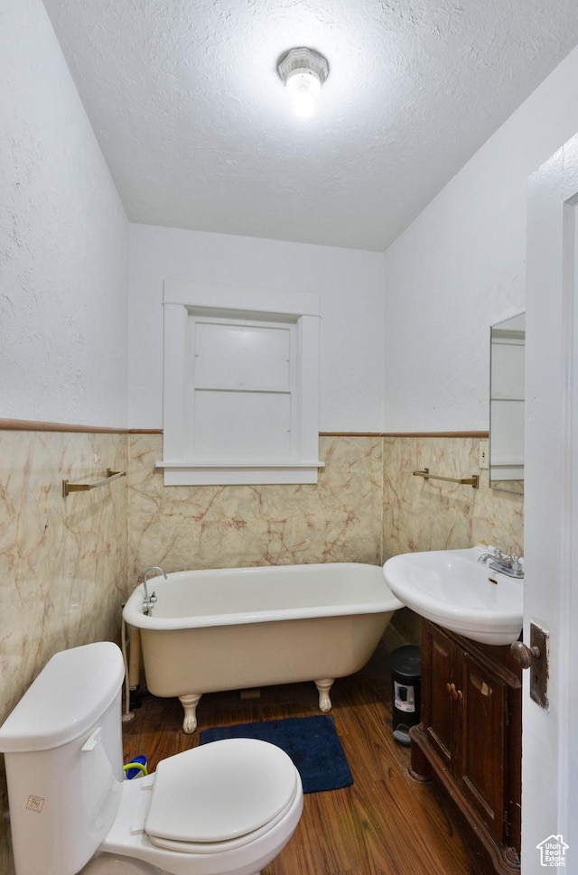 97 N 400 W, Aurora, UT 84620 - full bathroom featuring tile walls, a wainscoted wall, toilet, a freestanding tub, and vanity
