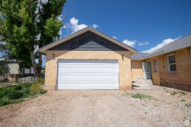 97 N 400 W, Aurora, UT 84620 - view of front facade featuring dirt driveway, stucco siding, a garage, and metal roof