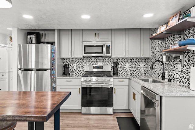 159 E Tranquil Cir, Saratoga Springs, UT 84045 - kitchen with stainless steel appliances, a sink, open shelves, decorative backsplash, and recessed lighting