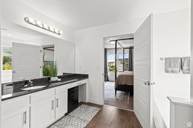 159 E Tranquil Cir, Saratoga Springs, UT 84045 - ensuite bathroom featuring double vanity, wood finished floors, a bath, and baseboards