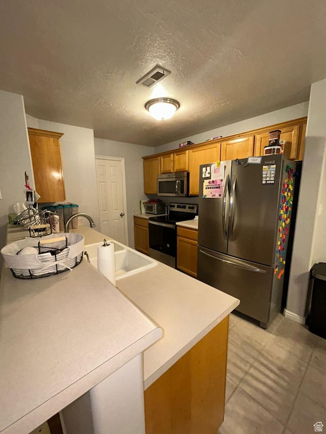 3878 W Sage Willow Dr, South Jordan, UT 84009 - kitchen with appliances with stainless steel finishes, brown cabinetry, light countertops, a textured ceiling, and a sink