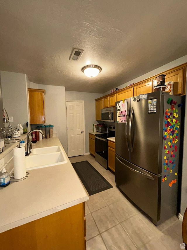 3878 W Sage Willow Dr, South Jordan, UT 84009 - kitchen featuring stainless steel appliances, a sink, brown cabinetry, light countertops, and light tile patterned flooring