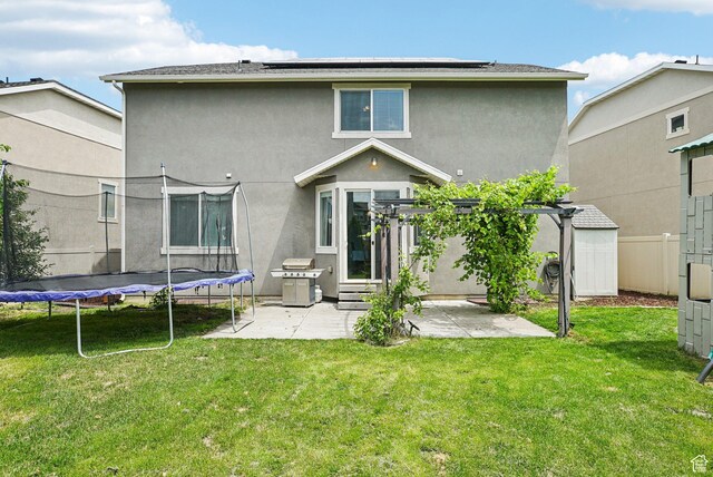 13326 S Rochdale Ln W, Herriman, UT 84096 - back of property with a trampoline, a patio, stucco siding, and solar panels
