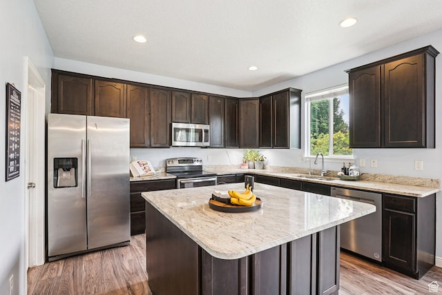 13326 S Rochdale Ln W, Herriman, UT 84096 - kitchen featuring appliances with stainless steel finishes, dark brown cabinetry, light wood-style flooring, light stone counters, and recessed lighting