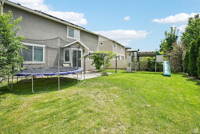 13326 S Rochdale Ln W, Herriman, UT 84096 - view of yard featuring a trampoline, a playground, and a patio