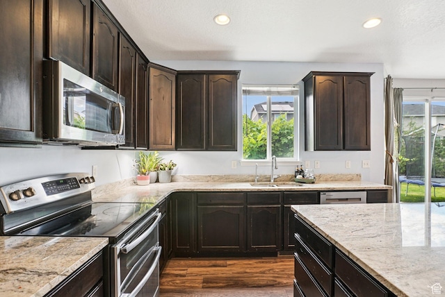 13326 S Rochdale Ln W, Herriman, UT 84096 - kitchen with appliances with stainless steel finishes, dark wood-style flooring, plenty of natural light, light stone countertops, and recessed lighting