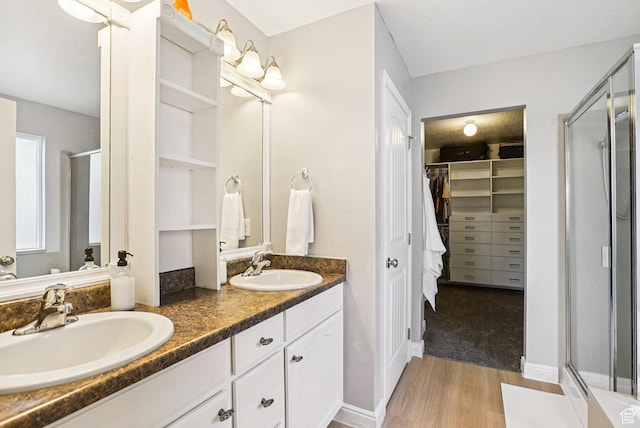 13326 S Rochdale Ln W, Herriman, UT 84096 - bathroom featuring a stall shower, wood finished floors, double vanity, and a spacious closet