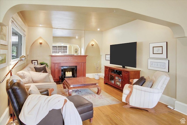 623 E Milton Ave, Salt Lake City, UT 84105 - living room featuring arched walkways, wood finished floors, a fireplace, and healthy amount of natural light