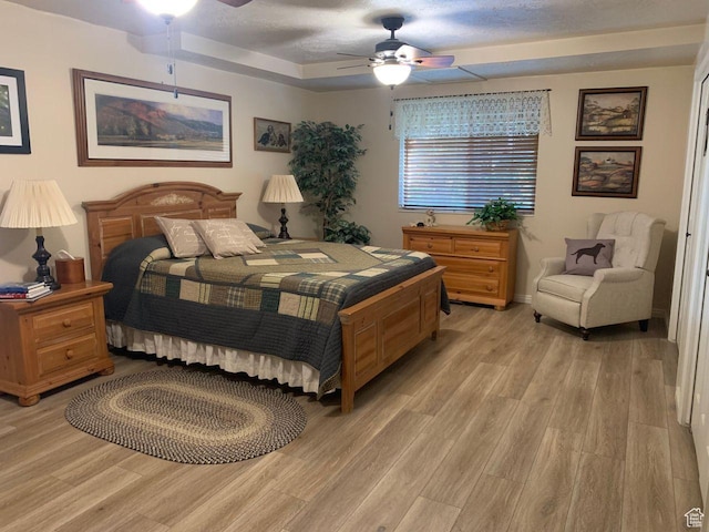 1262 W Dusty Downs Cir S, Jordan, UT 84095 - bedroom with light wood-style flooring, ceiling fan, and a raised ceiling