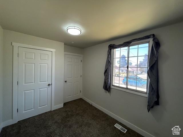 393 W 200 S, Tooele, UT 84074 - unfurnished bedroom featuring baseboards and dark colored carpet