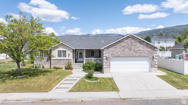 675 S 30 E, Ephraim, UT 84627 - ranch-style house featuring brick siding, a porch, driveway, a garage, and a mountain view