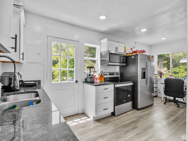 60 S Whiteside St, Layton, UT 84041 - kitchen featuring appliances with stainless steel finishes, white cabinets, dark stone countertops, recessed lighting, and a textured ceiling