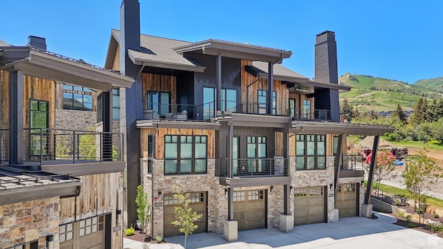 1988 Stone Creek Rd Unit 19, Park City, UT 84098 - back of house featuring a balcony, a chimney, stone siding, and a garage
