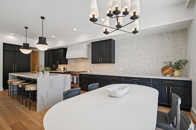 1990 Stone Creek Rd Unit 20, Park City, UT 84098 - kitchen featuring wall chimney range hood, stainless steel range, dark cabinetry, light wood-style flooring, and recessed lighting