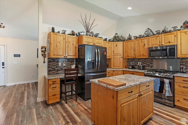 298 W 1775 N, Harrisville, UT 84414 - kitchen with stainless steel appliances, lofted ceiling, tasteful backsplash, a kitchen island, and light stone counters