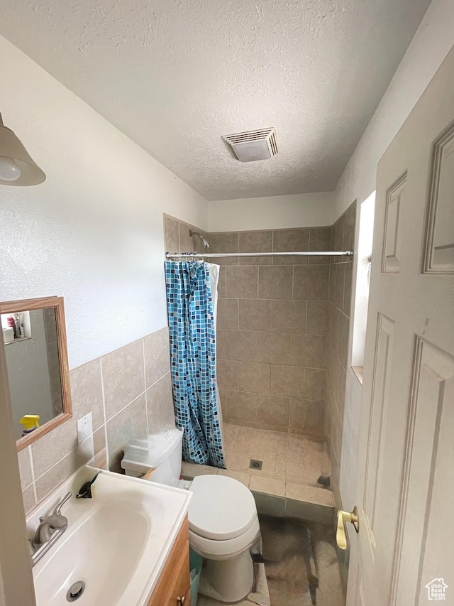 3301 S 1500 E, Vernal, UT 84078 - full bathroom featuring a stall shower, vanity, toilet, tile walls, and a textured ceiling