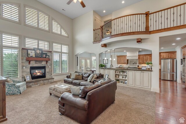 6663 W Normandy Way, Highland, UT 84003 - living area featuring a towering ceiling, recessed lighting, a ceiling fan, a fireplace, and arched walkways