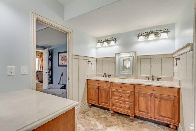6663 W Normandy Way, Highland, UT 84003 - full bath with double vanity, a wainscoted wall, ensuite bathroom, and a decorative wall