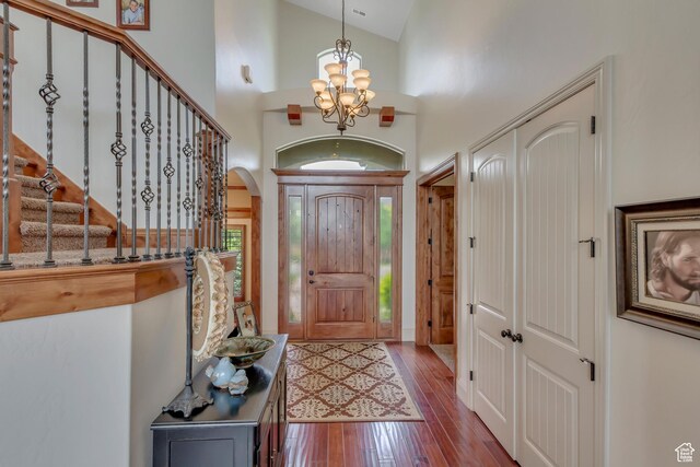 6663 W Normandy Way, Highland, UT 84003 - entrance foyer featuring a chandelier, hardwood / wood-style floors, high vaulted ceiling, arched walkways, and stairway