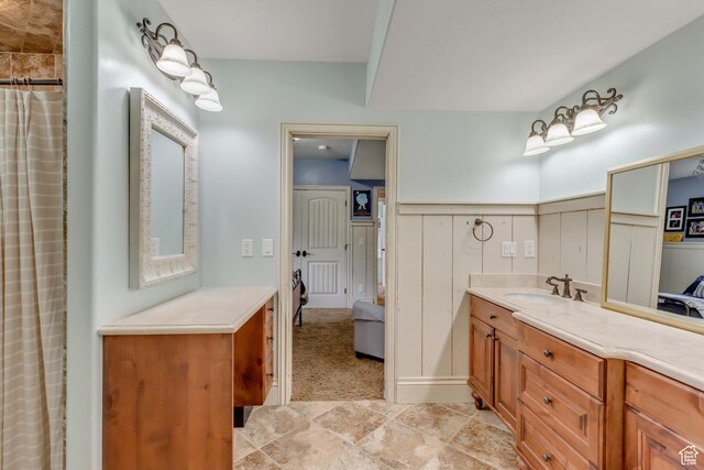 6663 W Normandy Way, Highland, UT 84003 - ensuite bathroom with vanity, wainscoting, curtained shower, and a decorative wall