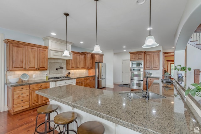 6663 W Normandy Way, Highland, UT 84003 - kitchen featuring appliances with stainless steel finishes, a sink, a kitchen breakfast bar, tasteful backsplash, and light stone counters