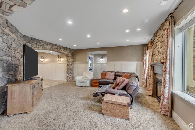 6663 W Normandy Way, Highland, UT 84003 - living room featuring a wainscoted wall, light colored carpet, decorative columns, recessed lighting, and a glass covered fireplace