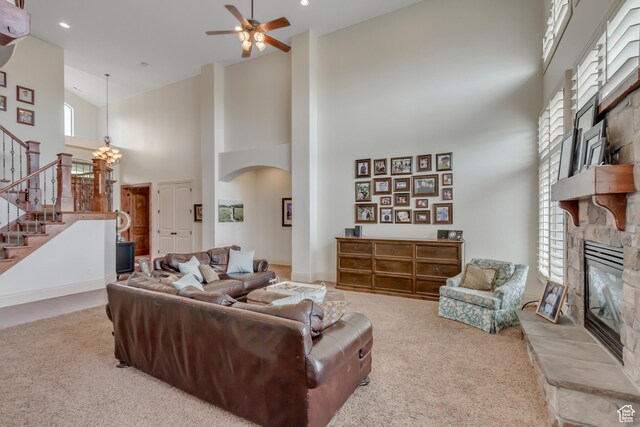 6663 W Normandy Way, Highland, UT 84003 - carpeted living area featuring a stone fireplace, high vaulted ceiling, stairway, a ceiling fan, and arched walkways