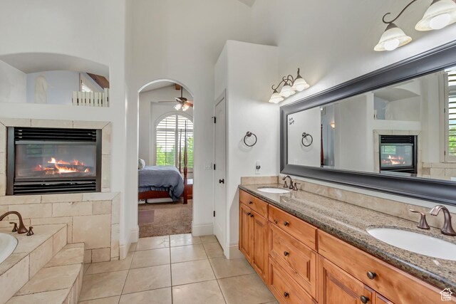 6663 W Normandy Way, Highland, UT 84003 - ensuite bathroom with a multi sided fireplace, double vanity, a garden tub, baseboards, and tile patterned floors
