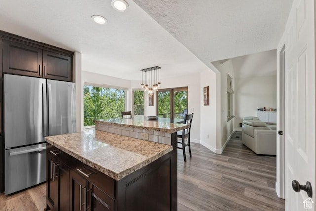 8086 N Meadowview Dr, Snyderville, UT 84098 - kitchen featuring freestanding refrigerator, a center island, wood finished floors, healthy amount of natural light, and recessed lighting