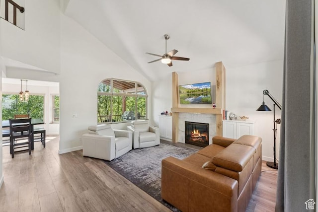 8086 N Meadowview Dr, Snyderville, UT 84098 - living area with wood finished floors, high vaulted ceiling, a ceiling fan, plenty of natural light, and a glass covered fireplace