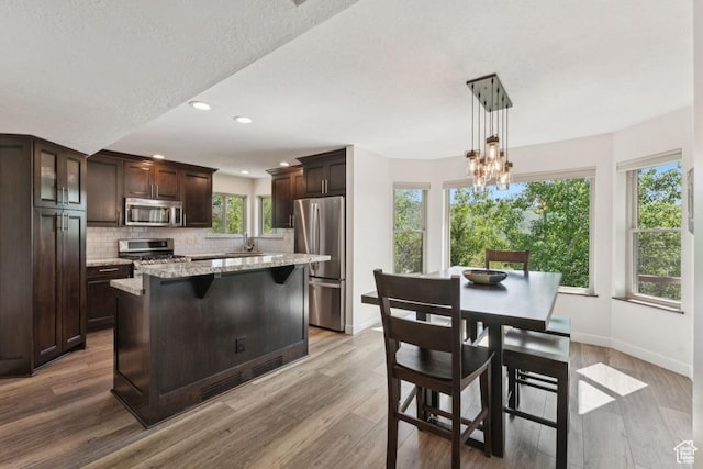 8086 N Meadowview Dr, Snyderville, UT 84098 - kitchen featuring stainless steel appliances, dark brown cabinets, tasteful backsplash, light wood finished floors, and recessed lighting
