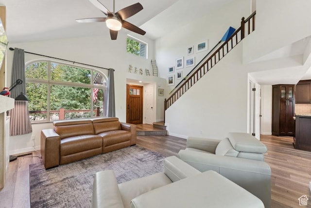 8086 N Meadowview Dr, Snyderville, UT 84098 - living area with wood finished floors, ceiling fan, high vaulted ceiling, baseboards, and stairway