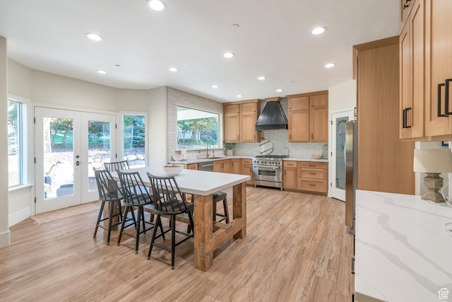 1110 S Woodland Hills Dr, Woodland Hills, UT 84653 - kitchen with stainless steel appliances, custom range hood, french doors, a breakfast bar area, and light wood finished floors