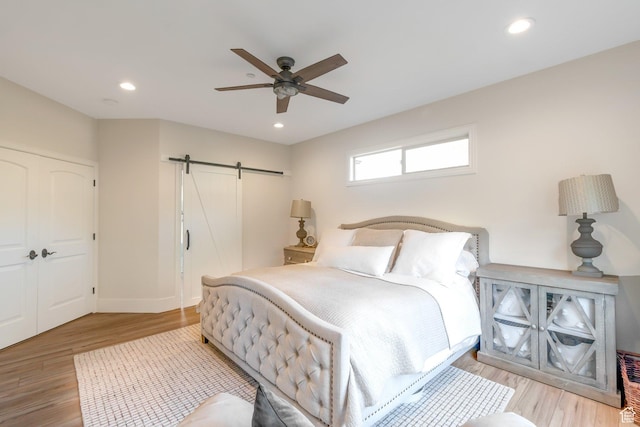 1110 S Woodland Hills Dr, Woodland Hills, UT 84653 - bedroom with a barn door, light wood-style floors, recessed lighting, a ceiling fan, and baseboards