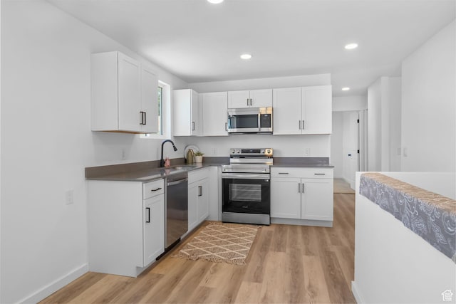 3717 W 8620 S, West Jordan, UT 84088 - kitchen featuring stainless steel appliances, a sink, light wood-style flooring, white cabinetry, and recessed lighting