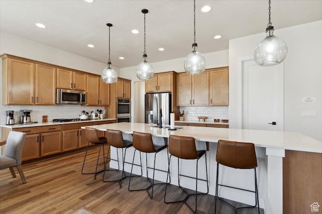 5936 N Angels Landing Dr, Mountain Green, UT 84050 - kitchen featuring appliances with stainless steel finishes, recessed lighting, backsplash, wood finished floors, and light countertops