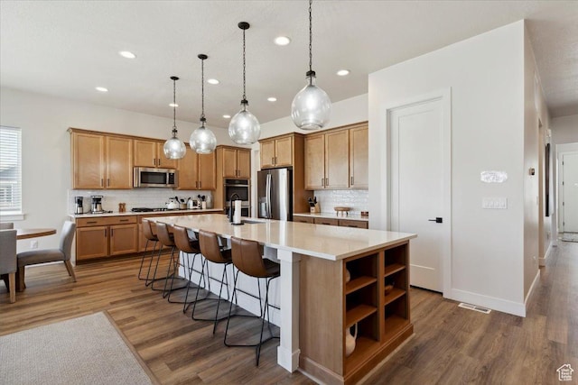 5936 N Angels Landing Dr, Mountain Green, UT 84050 - kitchen featuring appliances with stainless steel finishes, recessed lighting, wood finished floors, tasteful backsplash, and light countertops