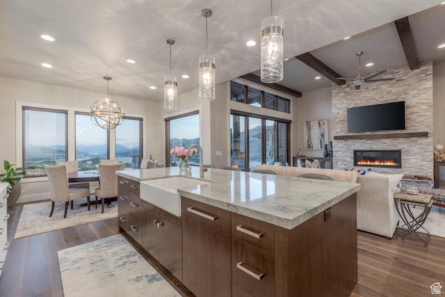 1136 E Black Hawk Way, Hideout, UT 84036 - kitchen with a sink, dark wood finished floors, a stone fireplace, light stone countertops, and beam ceiling