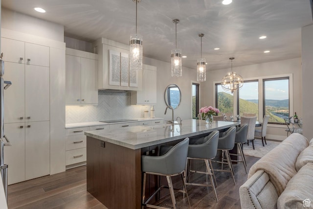 1136 E Black Hawk Way, Hideout, UT 84036 - kitchen featuring black electric stovetop, recessed lighting, a breakfast bar, backsplash, and a center island with sink