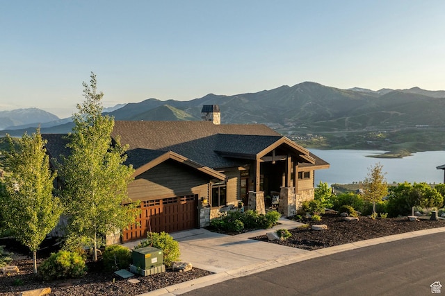 1136 E Black Hawk Way, Hideout, UT 84036 - craftsman-style home featuring a garage, concrete driveway, a chimney, a water and mountain view, and a shingled roof