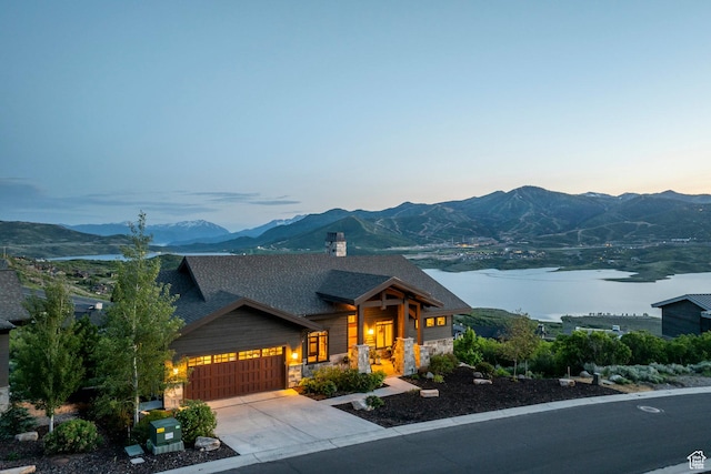 1136 E Black Hawk Way, Hideout, UT 84036 - view of front of house with a garage, a mountain view, stone siding, roof with shingles, and concrete driveway