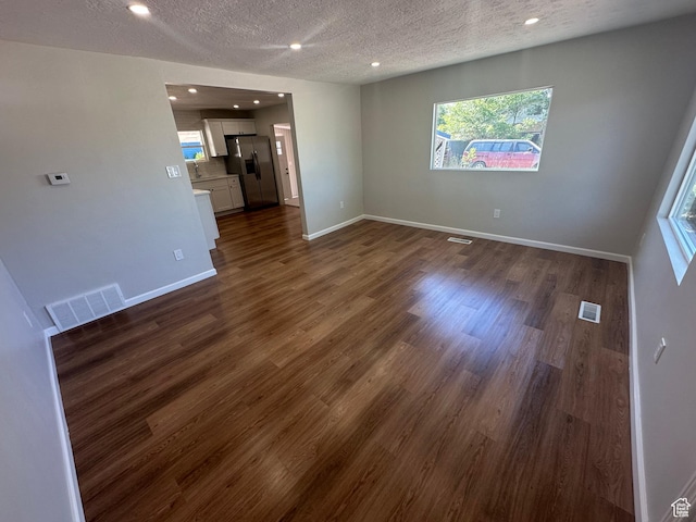 231 S 100th Ave E Unit 231, Willard, UT 84340 - empty room with a textured ceiling, dark wood-type flooring, recessed lighting, and baseboards