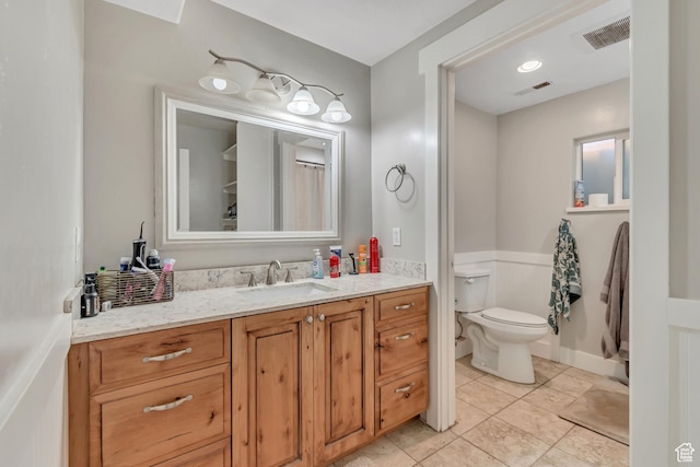 719 E Center St, Genola, UT 84655 - full bathroom featuring vanity, toilet, wainscoting, and tile patterned floors